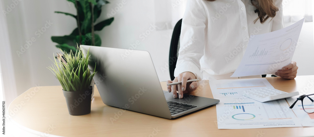 Businesswoman hand holding pen and pointing at financial paperwork with financial network diagram. Businesswoman hand holding pen and pointing at financial paperwork with financial network diagram.