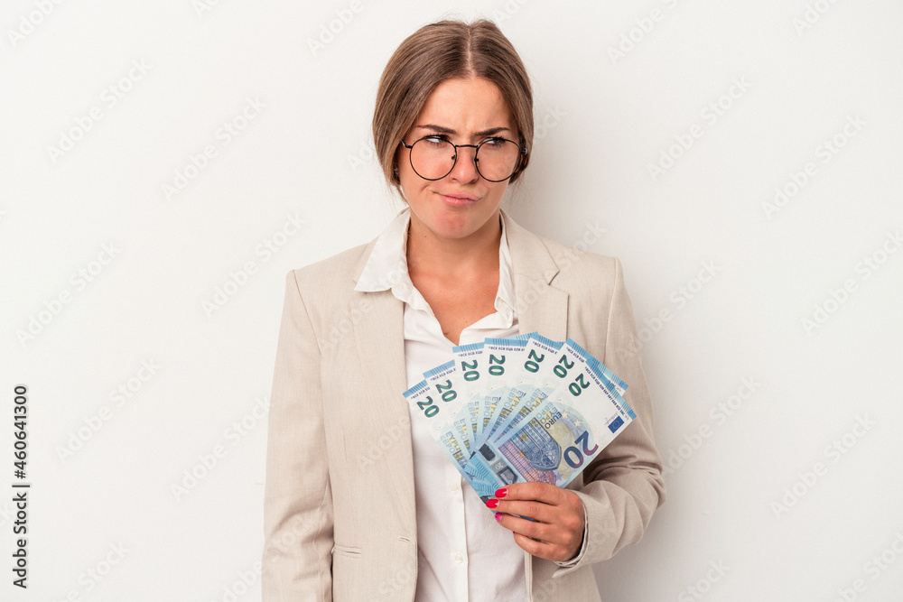 Young Russian business woman holding banknotes isolated on white background confused, feels doubtful and unsure. Young Russian business woman holding banknotes isolated on white background confused, feels doubtful and unsure.
