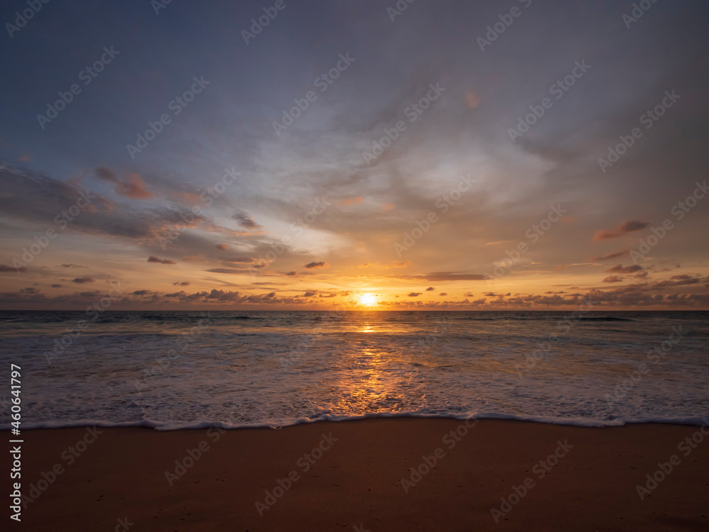 Beautiful sunset over the calm sea with cloud sky background. Sunset over tropical beach. Nature summer  concept. Peak sunset over sea with yellow light reflect on sea water. Tranquil seascape.