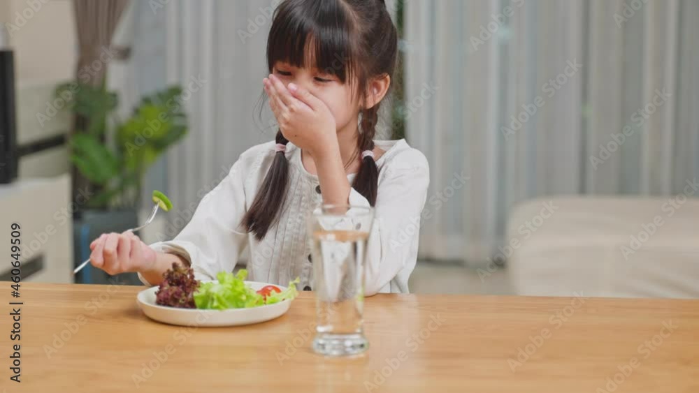 Unhappy Asian young girl don't want to eat vegetables on dinner plate. Unhappy Asian young girl don't want to eat vegetables on dinner plate.