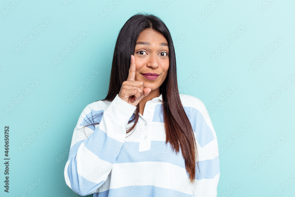 Young Venezuelan woman isolated on blue background showing number one with finger.