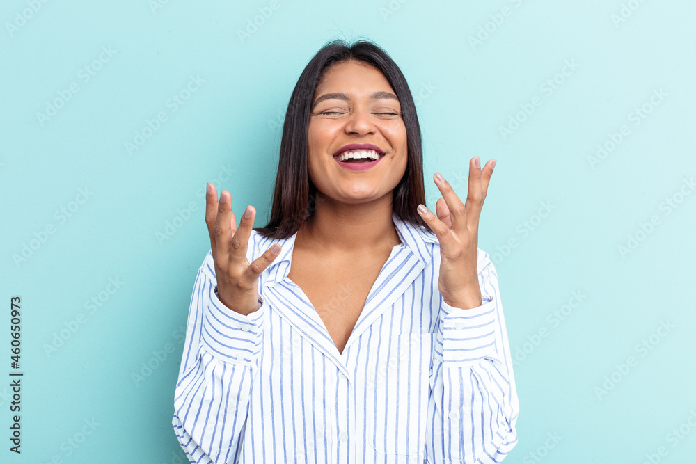 Young Venezuelan woman isolated on blue background laughs out loudly keeping hand on chest. Young Venezuelan woman isolated on blue background laughs out loudly keeping hand on chest.