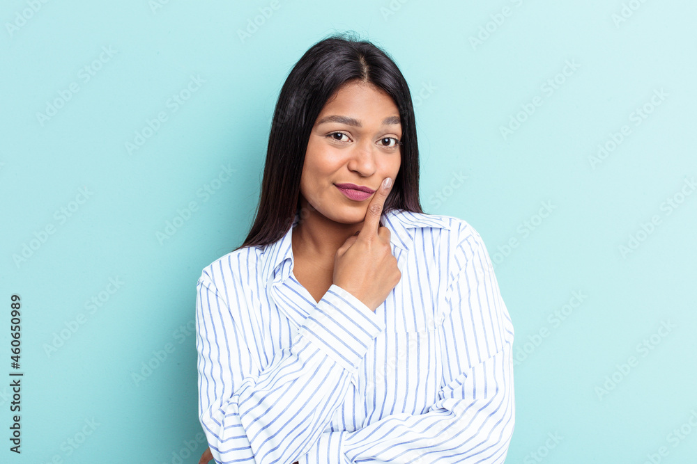 Young Venezuelan woman isolated on blue background looking sideways with doubtful and skeptical expression. Young Venezuelan woman isolated on blue background looking sideways with doubtful and skeptical expression.