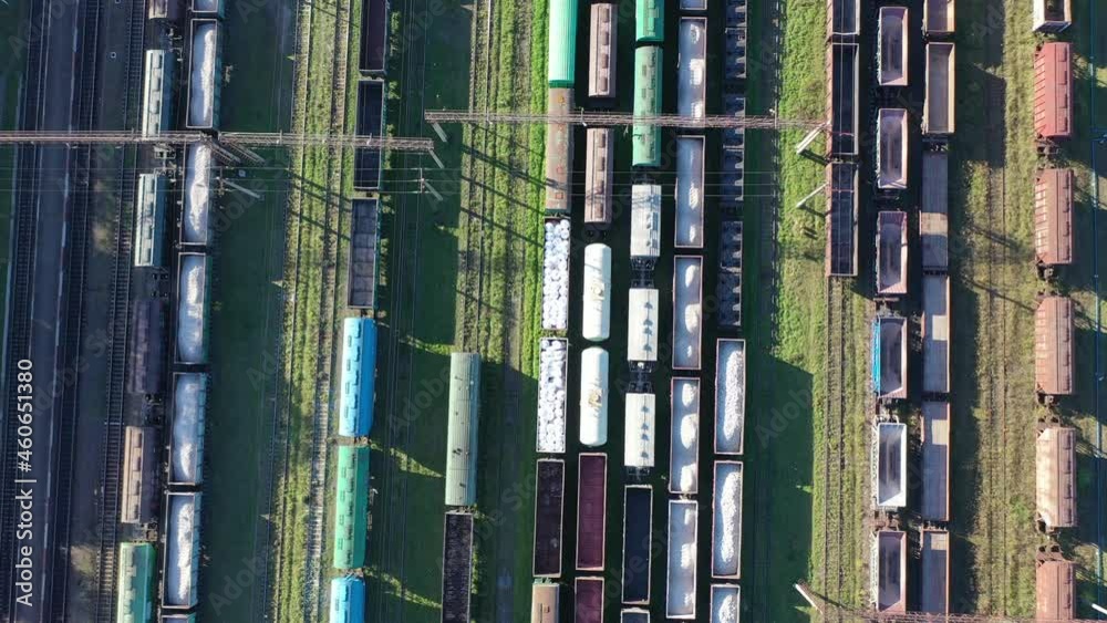 Cargo trains close-up. Aerial view of colorful freight trains on the railway station. Wagons with goods on railroad. Heavy industry. Industrial conceptual scene with trains. Top view from flying drone Cargo trains close-up. Aerial view of colorful freight trains on the railway station. Wagons with goods on railroad. Heavy industry. Industrial conceptual scene with trains. Top view from flying drone