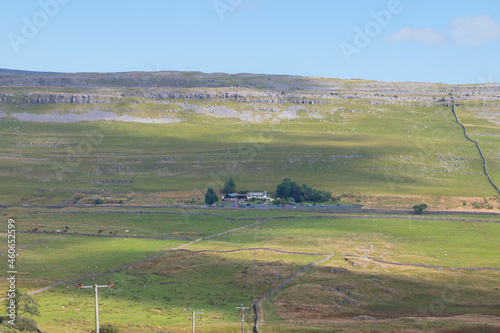 Landscape view of White Scar Cave entrance and surrounding countryside, valley and farmland in the Yorkshire Dales National Park photo