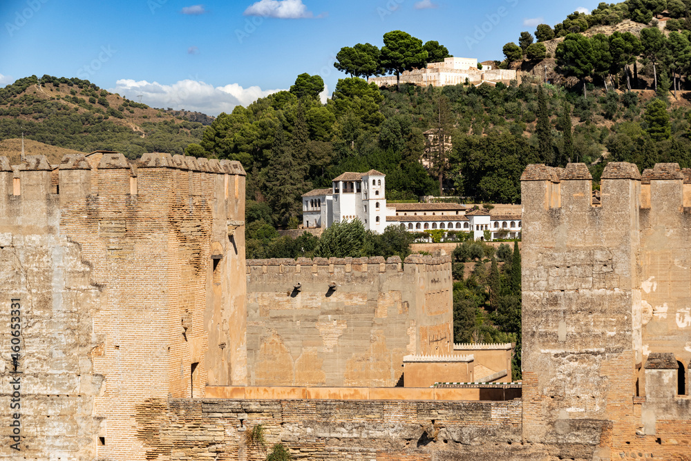 Distant view of the Generalife Palace (Palacio de Generalife) over the towers of the Alcazaba fortress, Alhambra de Granada UNESCO World Heritage Site, Granada, Andalusia, Spain