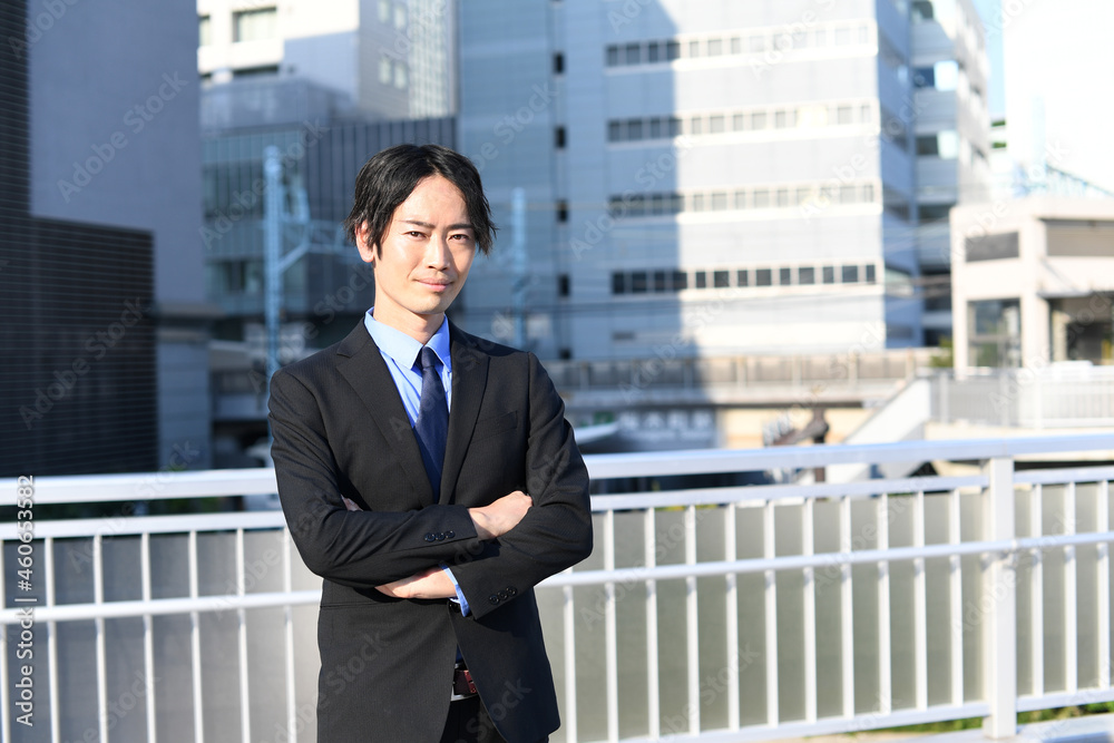 街中にいる腕組みをするスーツ姿の笑顔の男性 Foto De Stock Adobe Stock