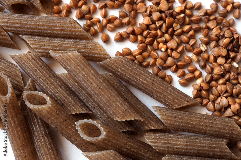 Closeup flatlay of pasta penne y grains buchwheat. For design, printing, packaging, items on the site. Closeup flatlay of pasta penne y grains buchwheat. For design, printing, packaging, items on the site.