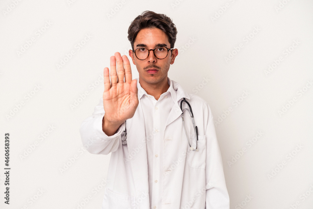 Young mixed race doctor man isolated on white background standing with outstretched hand showing stop sign, preventing you. Young mixed race doctor man isolated on white background standing with outstretched hand showing stop sign, preventing you.