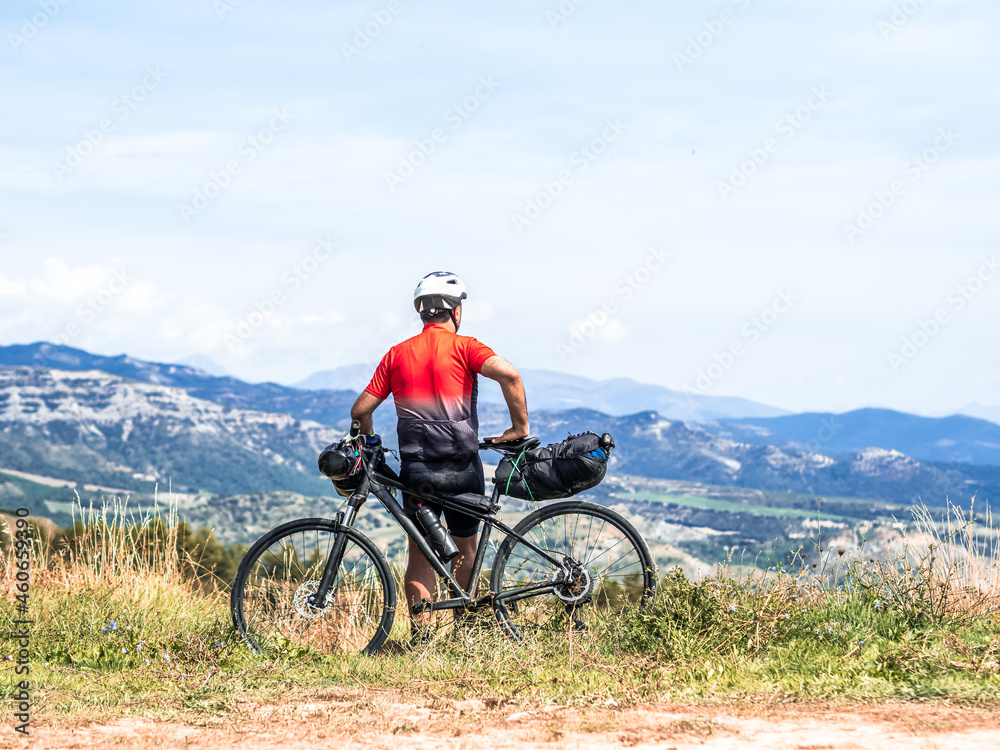 Unrecognizable man traveler with a bicycle looking at the mountains.Bikepacking 