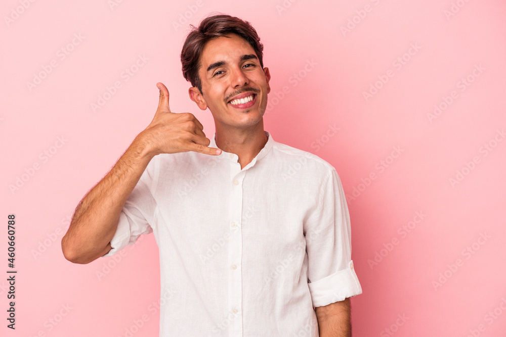 Young mixed race man isolated on white background showing a mobile phone call gesture with fingers. Young mixed race man isolated on white background showing a mobile phone call gesture with fingers.