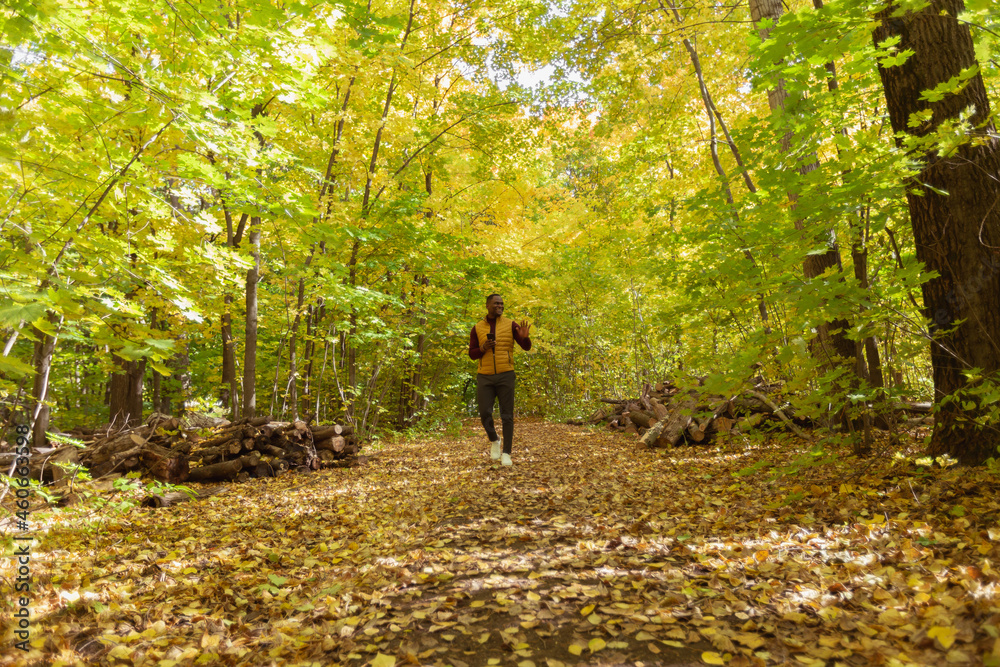 Male student walking in the park in autumn season Male student walking in the park in autumn season