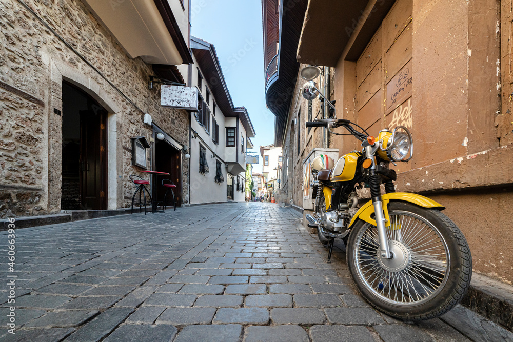 Fototapeta premium cozy streets of kaleichi in antalya motorcycle parked on an empty cozy street. peace and quiet in the historical center of Antalya in Turkey. travel and tourism