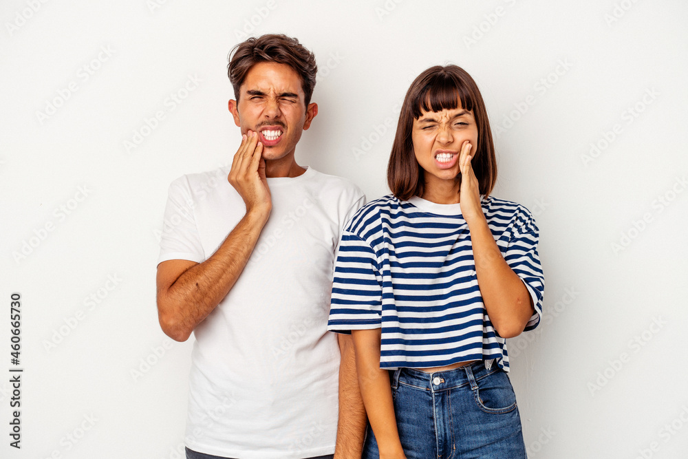 Young mixed race couple isolated on white background having a strong teeth pain, molar ache. Young mixed race couple isolated on white background having a strong teeth pain, molar ache.