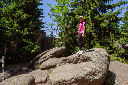 Happy little girl on the top of rock formation in the forest © mitarart