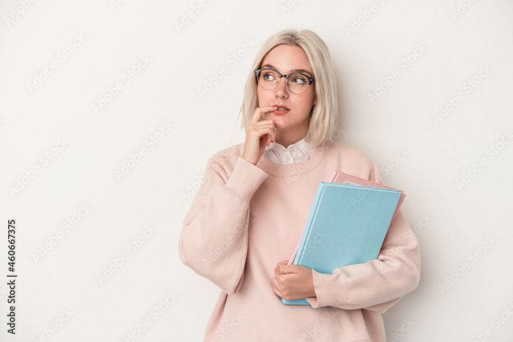Young caucasian student woman holding books isolated on white background relaxed thinking about something looking at a copy space. Young caucasian student woman holding books isolated on white background relaxed thinking about something looking at a copy space.