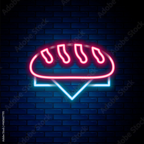 Glowing neon line Bread loaf icon isolated on brick wall background. Colorful outline concept. Vector