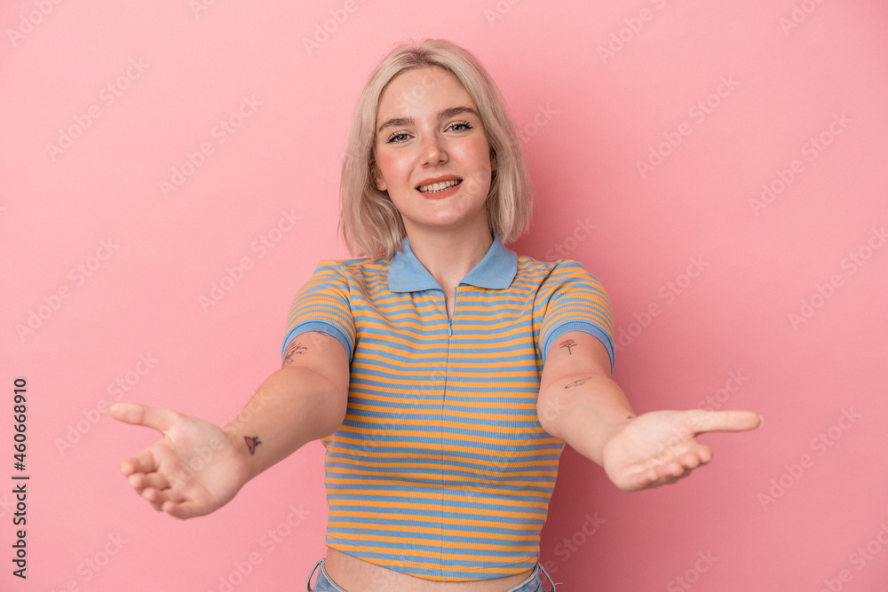 Young caucasian woman isolated on pink background showing a welcome expression. Young caucasian woman isolated on pink background showing a welcome expression.