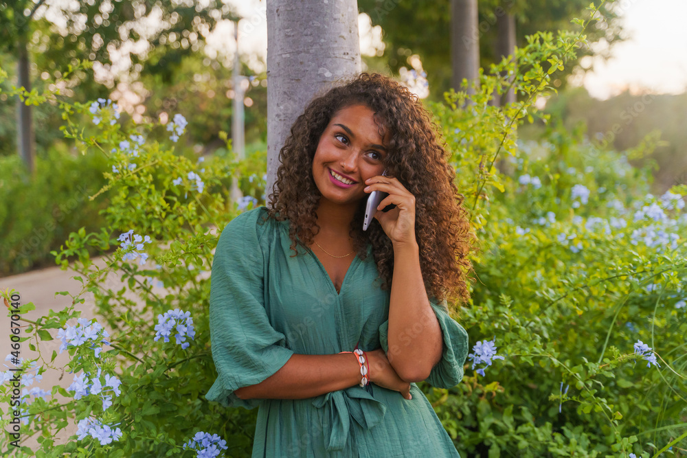 Fototapeta premium Hispanic woman smiling while talking on the phone