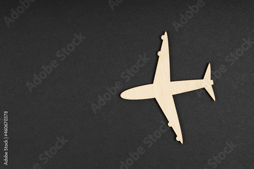 A wooden plane lies on a black background. Isolated.