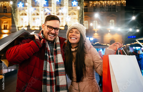 Portrait of happy couple shopping for Christmas in the city. People holiday happiness sale concept © NDABCREATIVITY