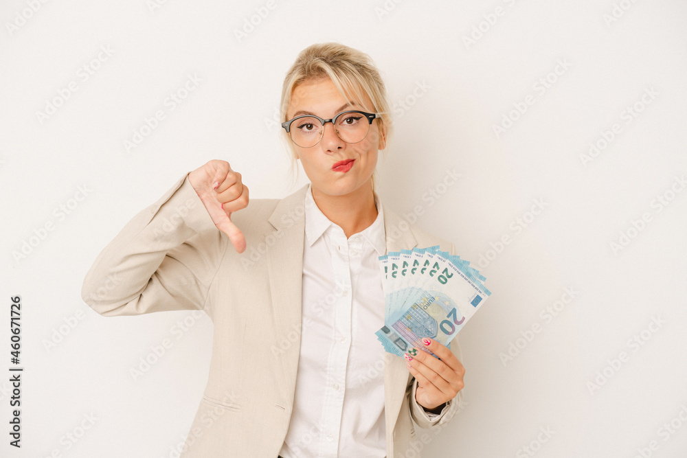 Young business Russian woman holding banknotes isolated on white background showing a dislike gesture, thumbs down. Disagreement concept.