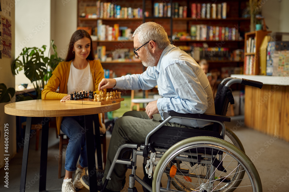 Disabled grandfather and granddaughter play chess Disabled grandfather and granddaughter play chess