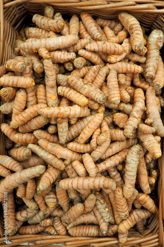 turmeric root lies in a wicker basket in a supermarket. view from above photo