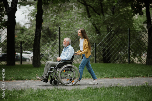 Daughter and disabled father on a walking path photo