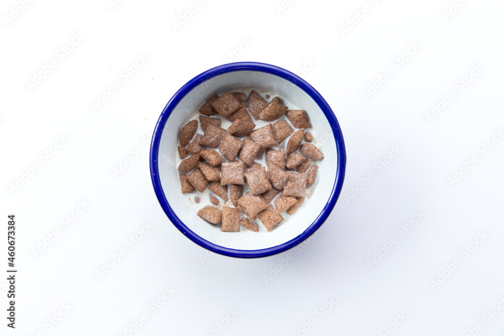 Dry breakfast pads. With milk. In a plate. Isolated on white. Dry breakfast pads. With milk. In a plate. Isolated on white.