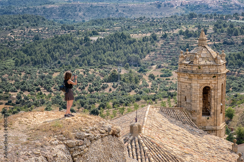 Girl photographing the bell tower of La Fresnada village photo