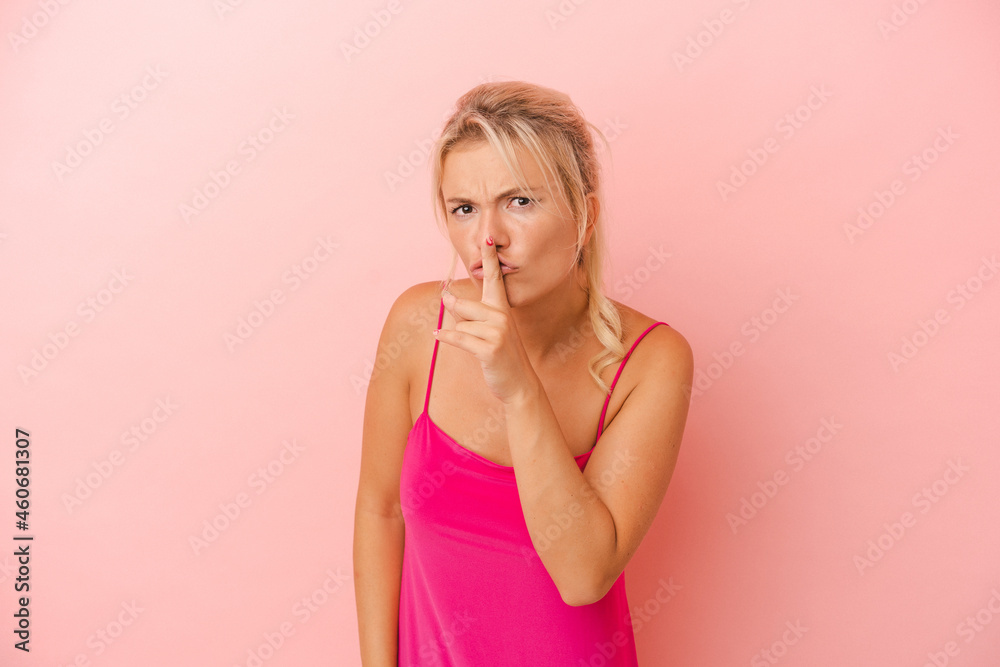 Young Russian woman isolated on pink background keeping a secret or asking for silence. Young Russian woman isolated on pink background keeping a secret or asking for silence.