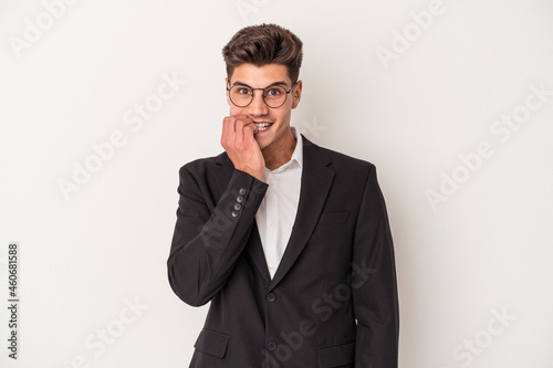 Young business caucasian man isolated on white background biting fingernails, nervous and very anxious.