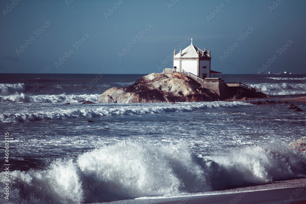Ocean surf at Miramar Beach, chapel Senhor da Pedra, Porto, Portugal..