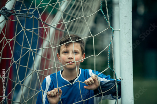 Boy, a little football player near the gates of the stadium.