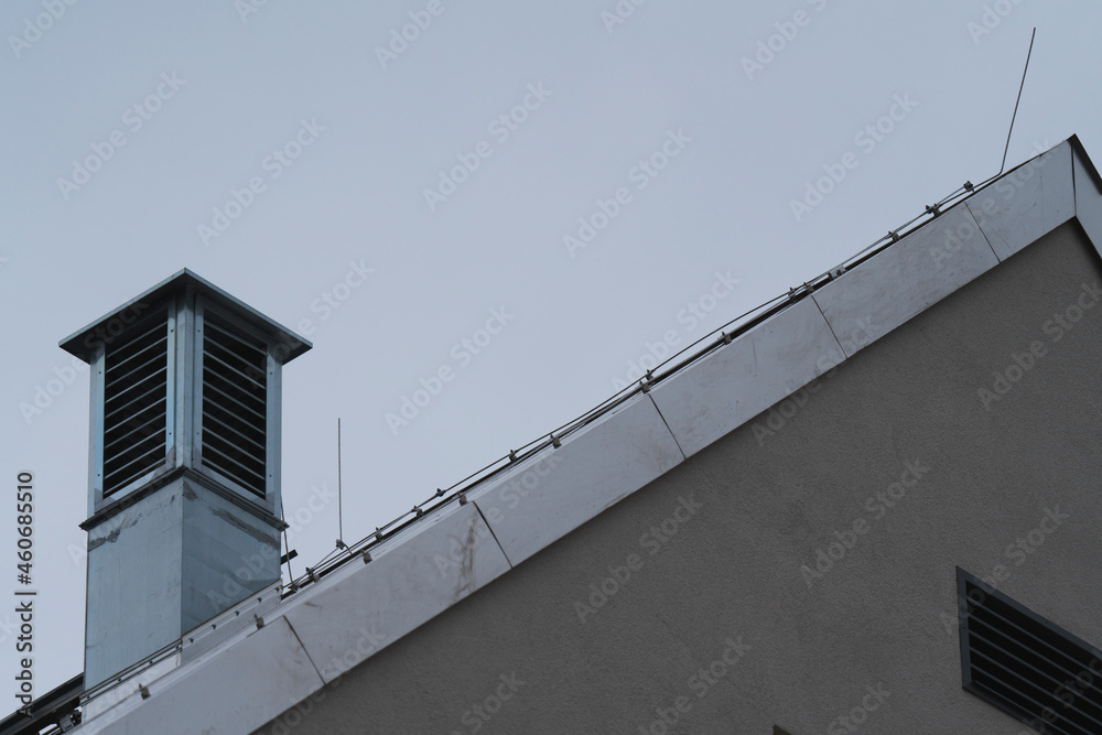 a metallic roof with a metallic chimney with a blue sky in the background a metallic roof with a metallic chimney with a blue sky in the background
