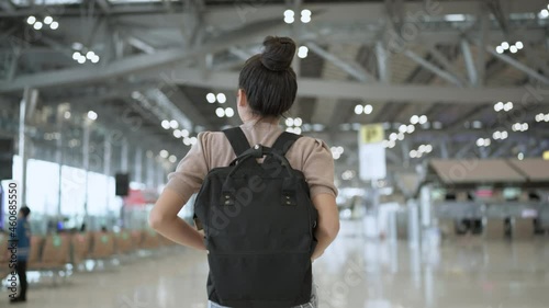 lockdown is over time to travel,happiness attractive traveller asian femlae casual cloth hand wave gesture smiling walking along in terminal airport cheerful smile happiness safety travel concept photo