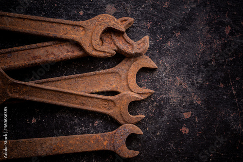 Old rusty wrenches on a dark background