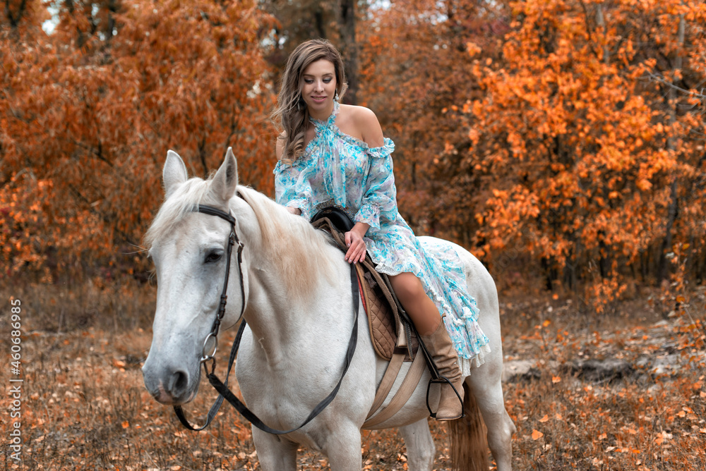 Fototapeta premium Young woman in the park with a horse