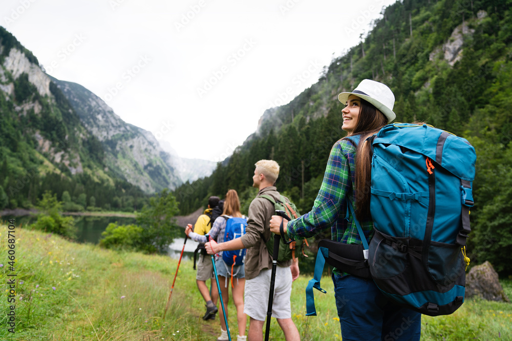 Group of happy friends with backpacks hiking together Group of happy friends with backpacks hiking together