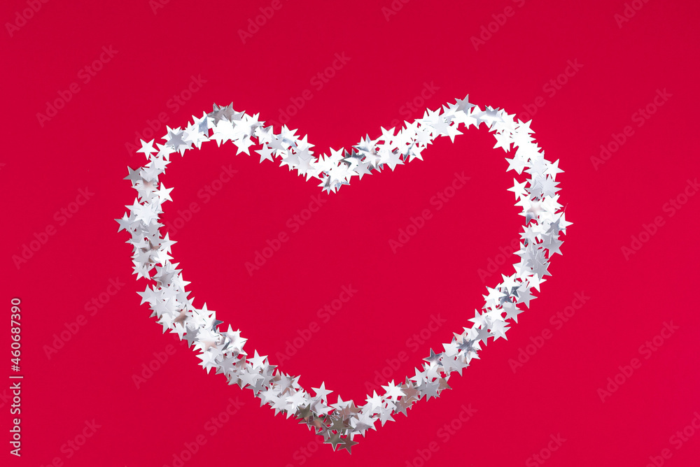 Merry Christmas big heart made of silver stars on a red festive background. Happy new year 2022