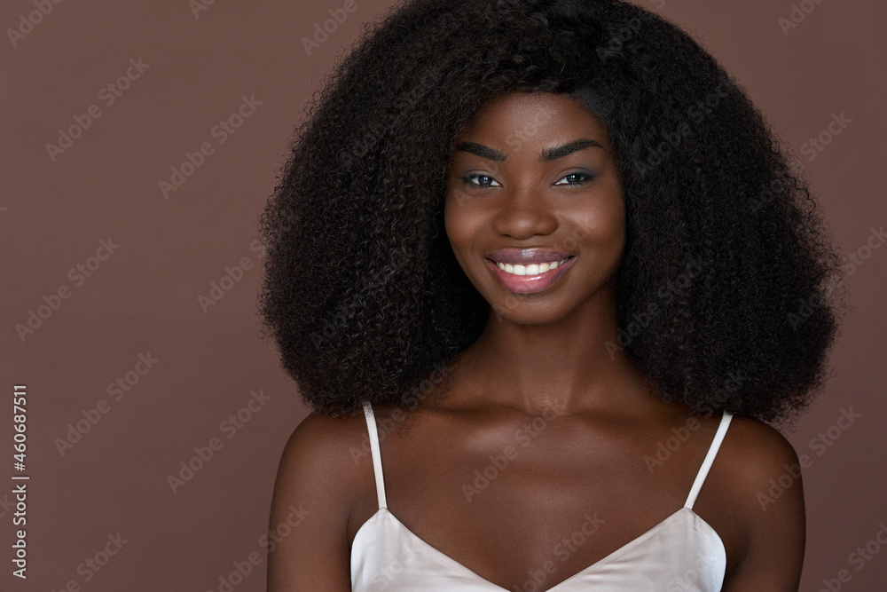 Happy attractive adult young 20s African American girl with perfect toothy smile isolated on brown background. Headshot close up front portrait. Beauty skincare cosmetology concept. Copy space. Happy attractive adult young 20s African American girl with perfect toothy smile isolated on brown background. Headshot close up front portrait. Beauty skincare cosmetology concept. Copy space.