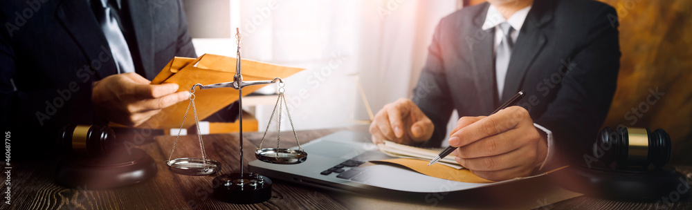 Business and lawyers discussing contract papers with brass scale on desk in office. Law, legal services, advice, justice and law concept Business and lawyers discussing contract papers with brass scale on desk in office. Law, legal services, advice, justice and law concept