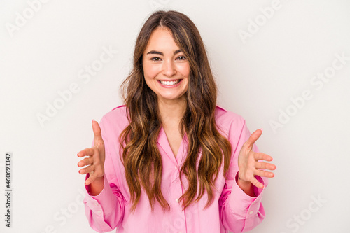 Young caucasian woman isolated on white background holding something with both hands, product presentation.