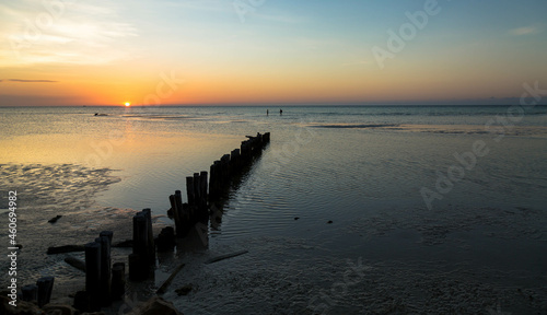 Beautiful sunset in the blue hour  in which the tide goes down and you can see the sand with small waves.