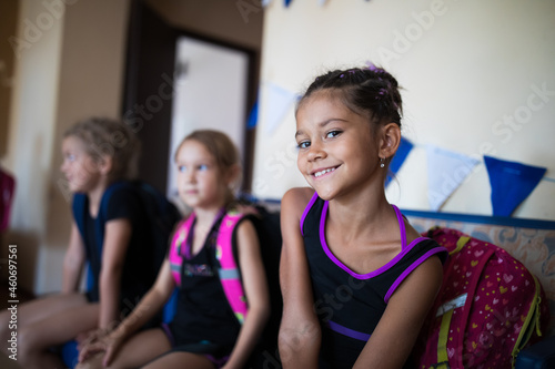 Portrait of smiling girl gymnast with backpack in sports camp 