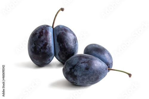 Ripe purple plums with a bluish bloom on white