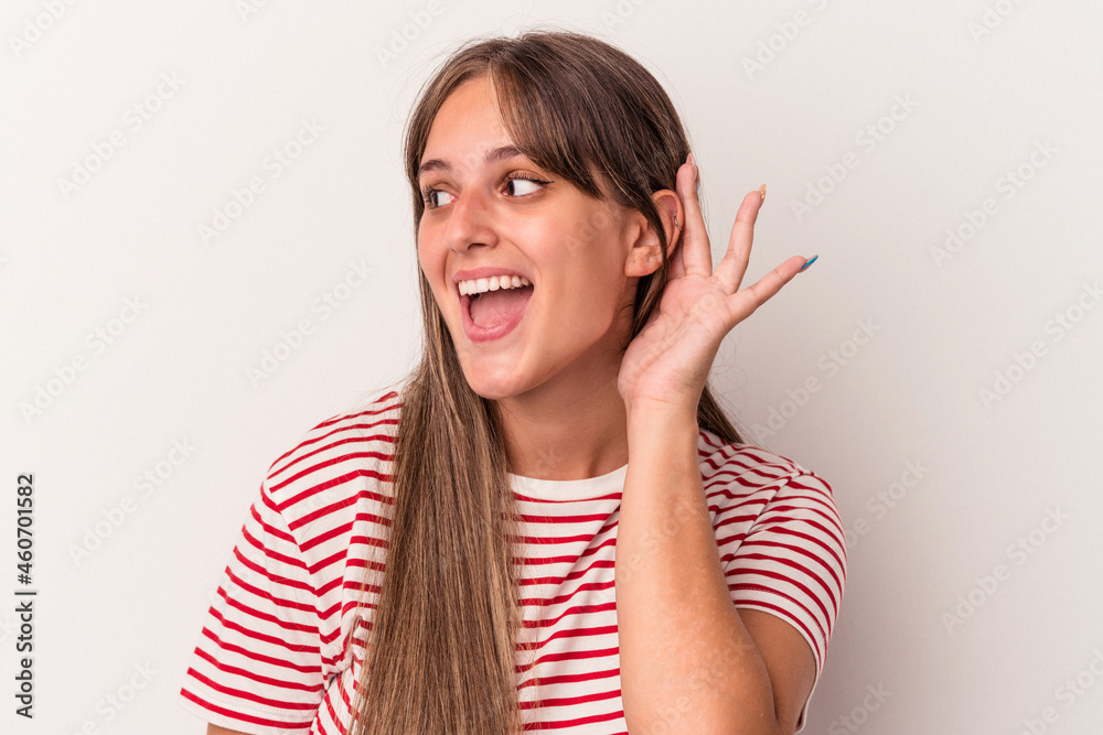 Young caucasian woman isolated on white background trying to listening a gossip. Young caucasian woman isolated on white background trying to listening a gossip.