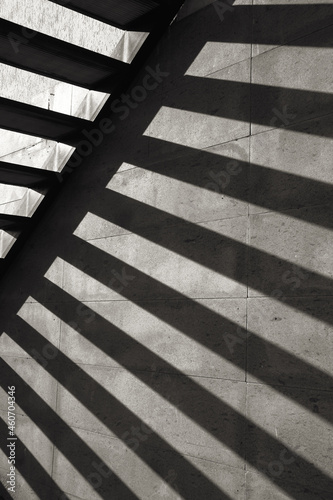 Sun's rays penetrate among the steps of the stairway and reflected on the wall. Black and white stairs in sunny day.