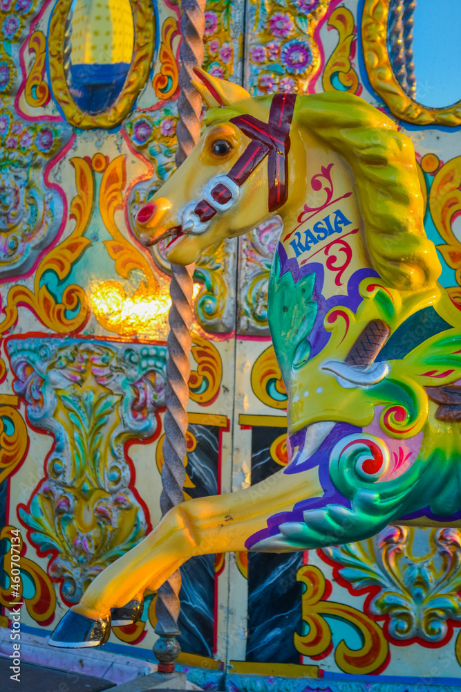 Fototapeta premium UK, Brigton, 01.10.2021: A carousel from Brighton Pier. The characters are horses and roosters, the back wall is also decorated and has mirrored inserts.